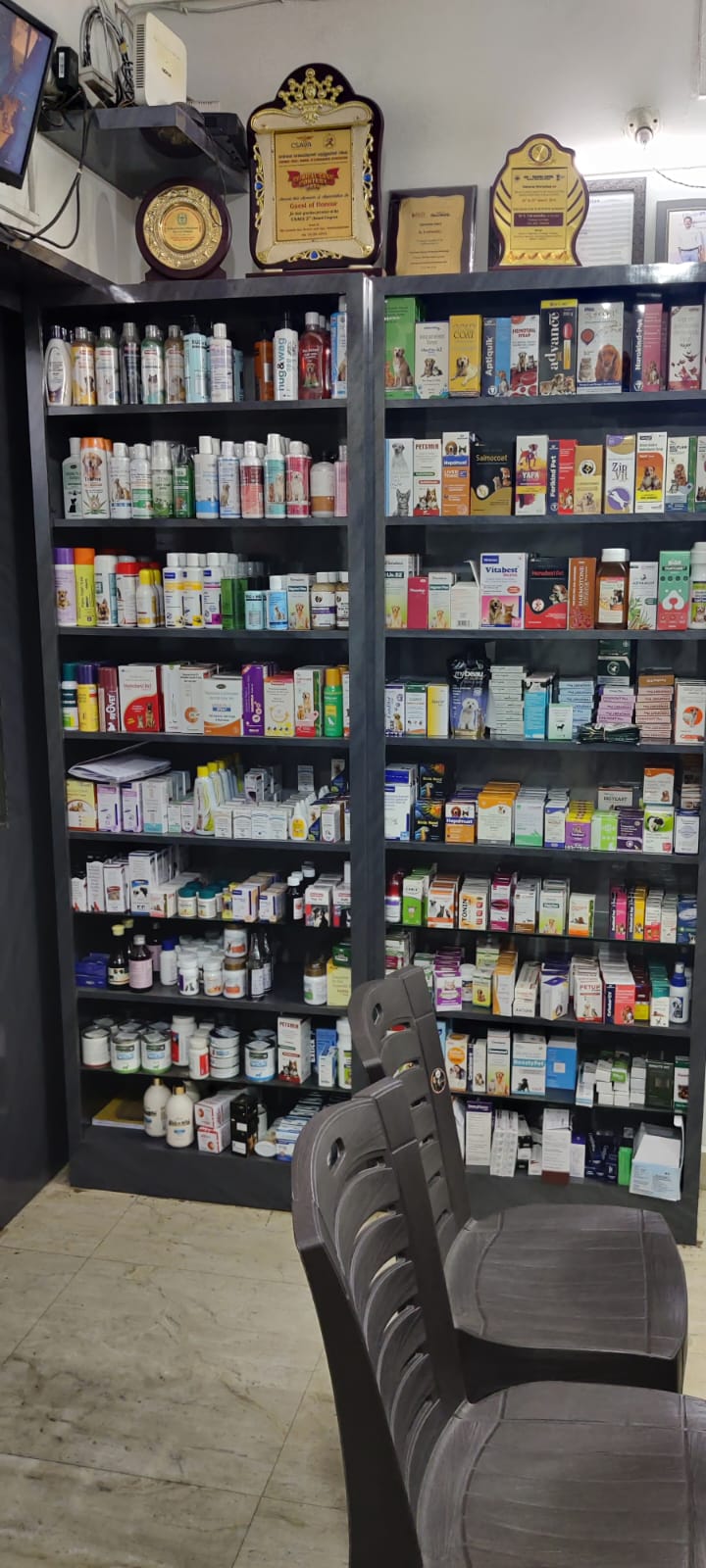 Well-stocked pharmacy shelves with awards above